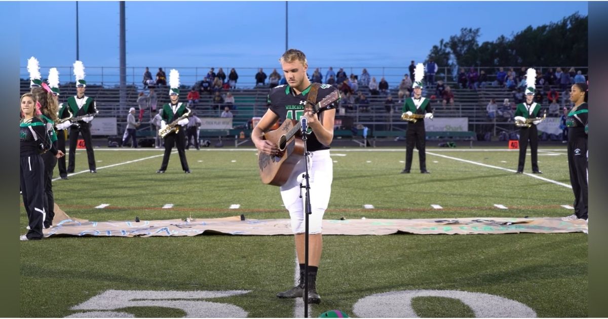 Football player removes helmet to sing national anthem when no one else
