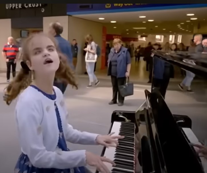 Blind little girl quiets the crowd when she begins playing the piano